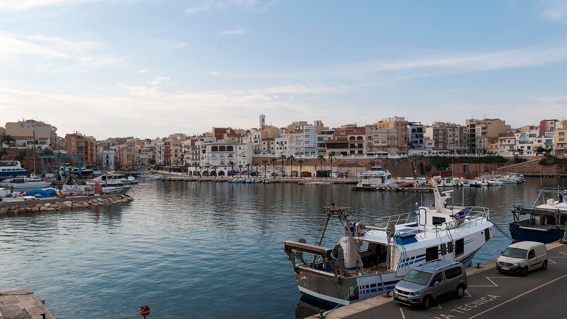 Fishing boats moored along a quay in a working Mediterranean harbour